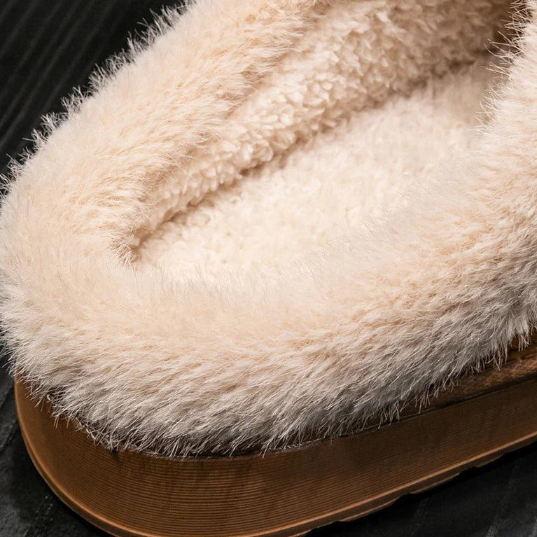 Close-up of a fluffy beige slipper on a dark background