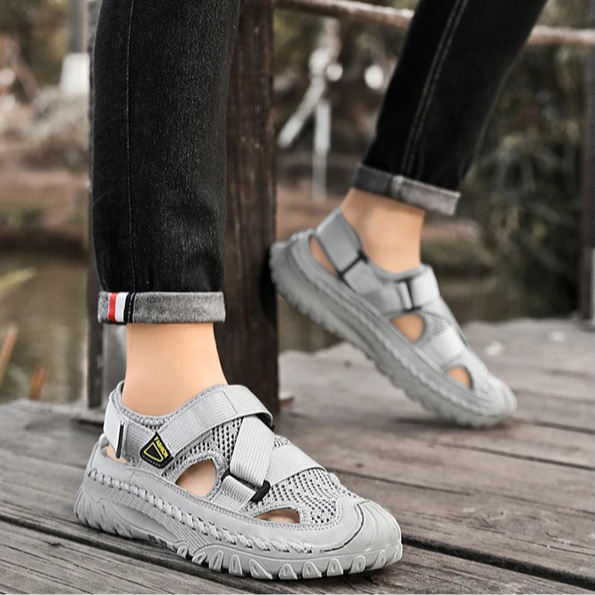 Gray sandals worn on a wooden surface with blurred background