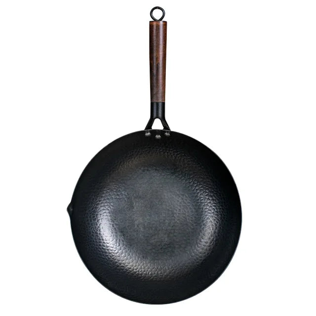 Black wok with a wooden handle on a white background