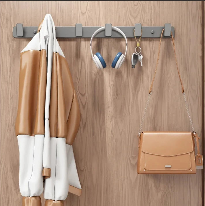 Coat, shoes, headphones, and a handbag hanging on a wooden door with a hook.