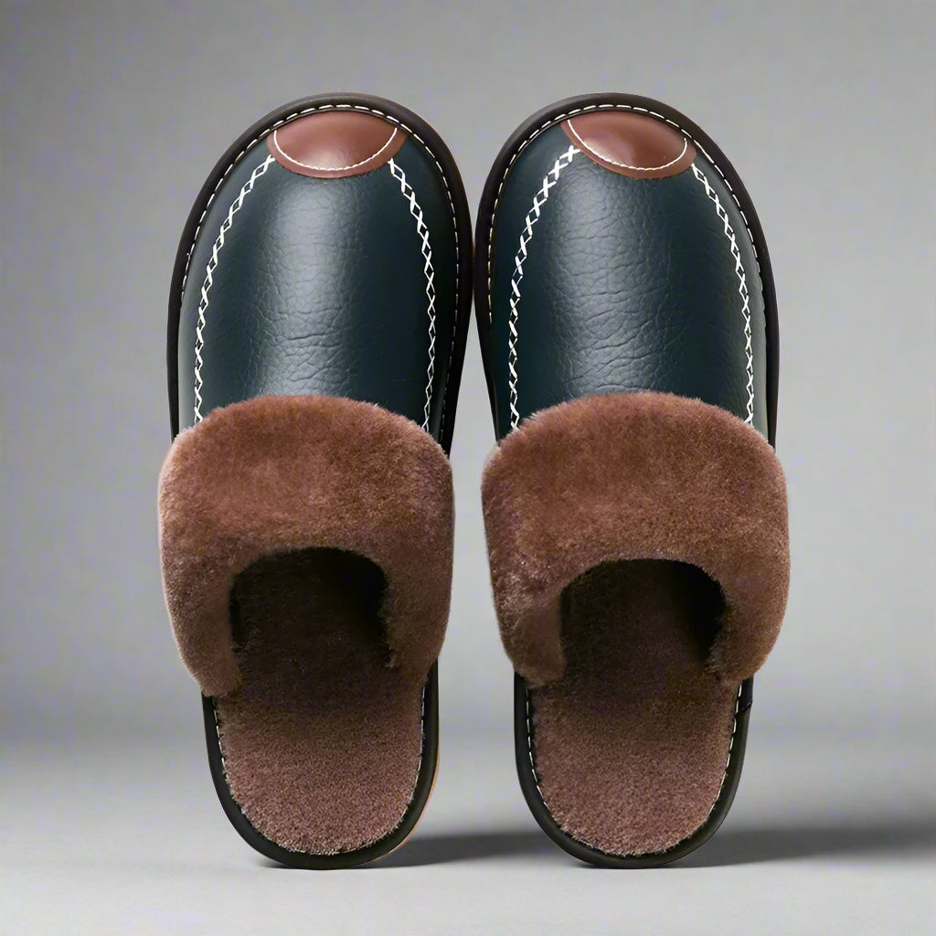 Pair of black slippers with brown fur on a white background