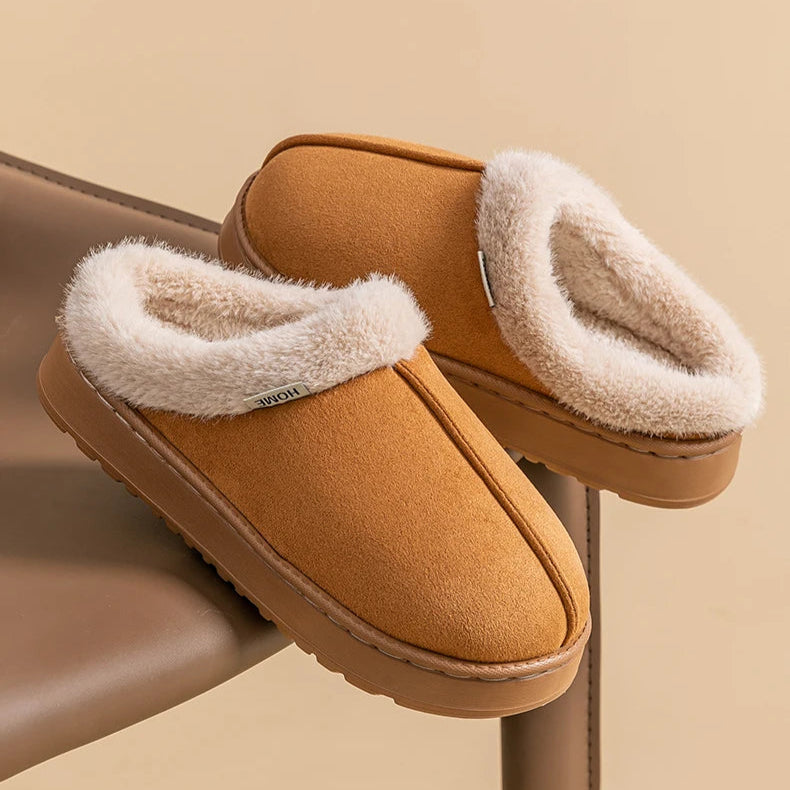 Pair of brown slippers with white fur lining on a beige background