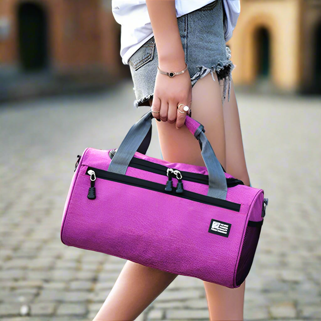 Person holding a purple duffel bag on a street