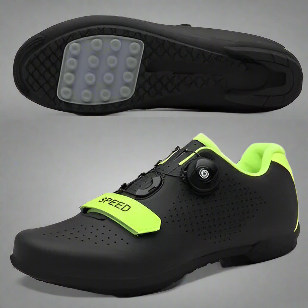 A person is adjusting the Velcro strap on a black cycling shoe with green accents, which is worn on a pedal of a bicycle.