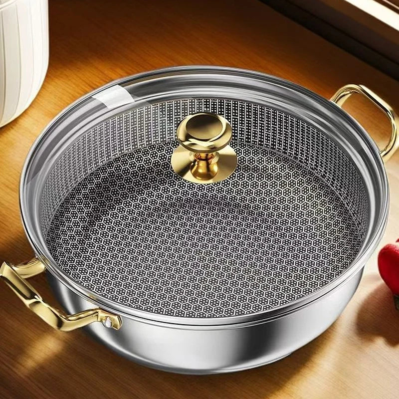 Metallic pan with a textured surface and gold handles on a wooden surface
