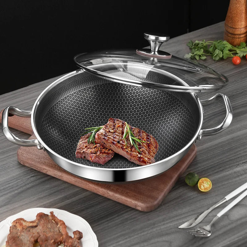 Stainless steel frying pan with honeycomb design containing seared meat on a wooden cutting board.