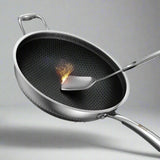 Stainless steel wok with a spatula on a light blue background