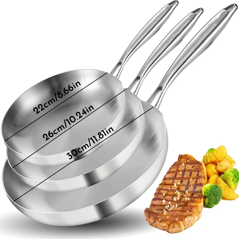Set of three stainless steel measuring cups shown with a steak and vegetables on a white background.