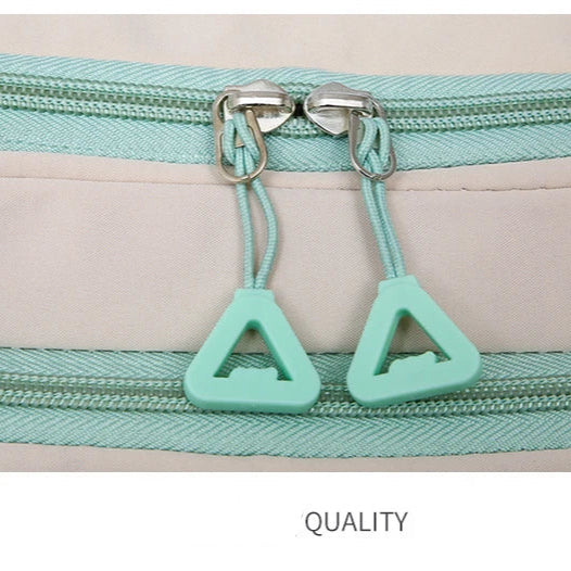 Close-up of a zipper with green pull tabs on a beige background