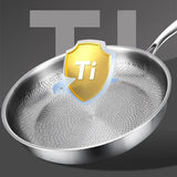 Stainless steel frying pan with a gold 'Ti' badge on a dark background