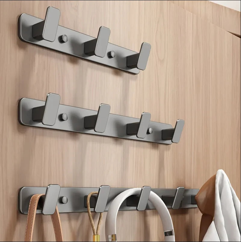 Set of metal hooks on a wooden wall with various items hanging from them.