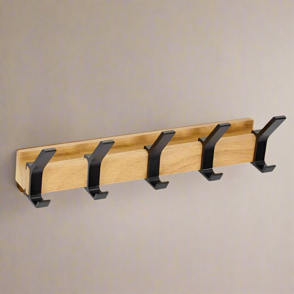 Wooden coat rack with black hooks on a white background