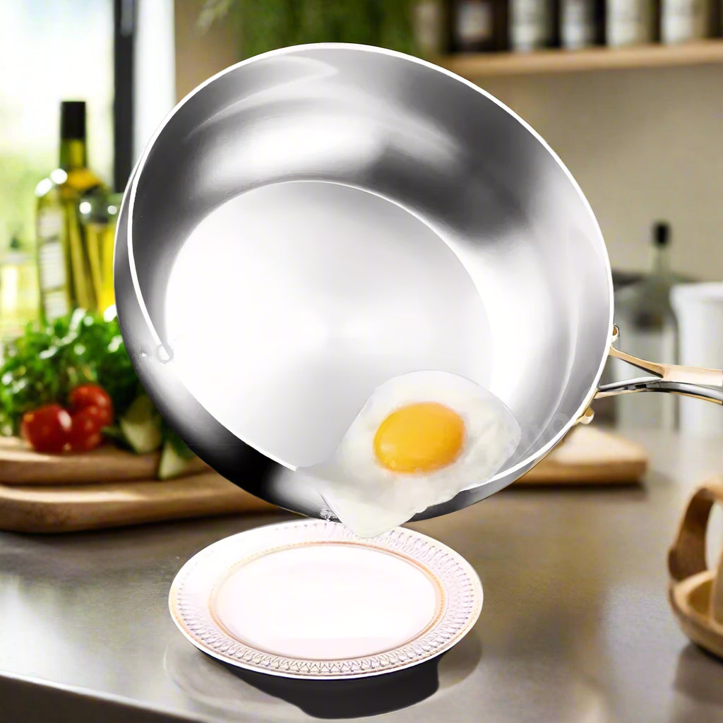 Stainless steel frying pan with a fried egg on a reflective surface