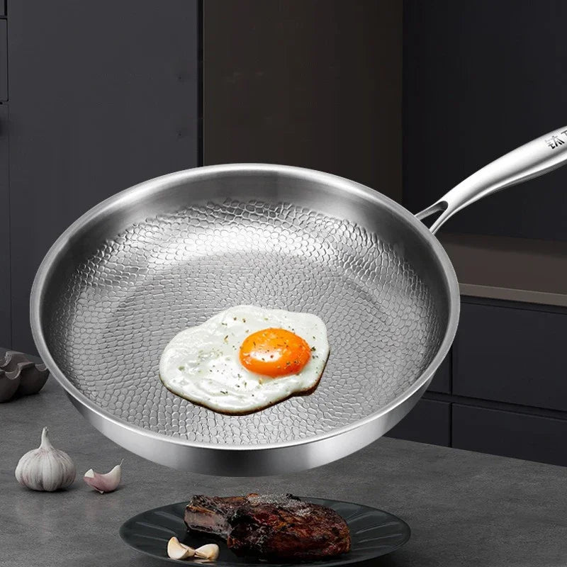 Stainless steel frying pan with a fried egg on a kitchen counter