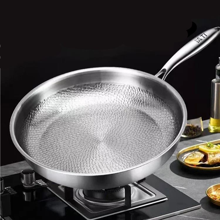 Titanium hammered frying pan on a stove with text highlighting benefits