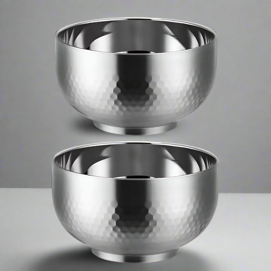 Two silver metallic bowls with a textured surface on a white background