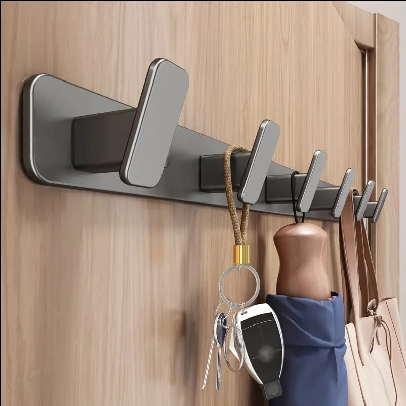Wall-mounted hook with multiple hooks holding keys, an umbrella, and a bag on a wooden door.