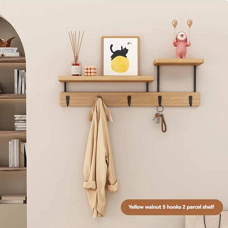 Wooden wall shelf with hooks and a small table against a beige wall.