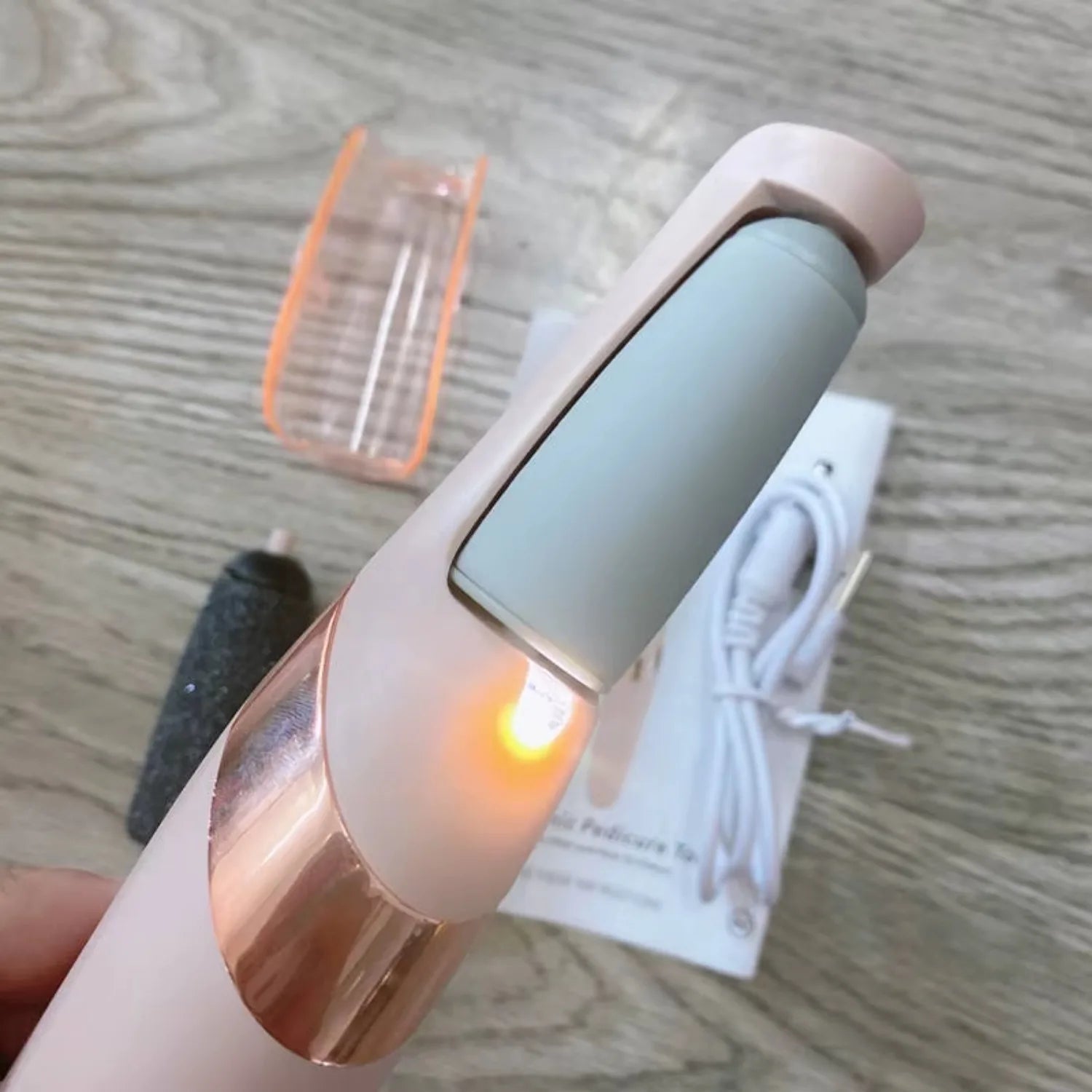 Portable electronic device with a glowing light on a wooden surface
