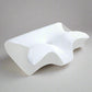 An ergonomic memory foam pillow with a contoured design, displayed in different settings showing its use for neck support and as a sleeping pillow.
