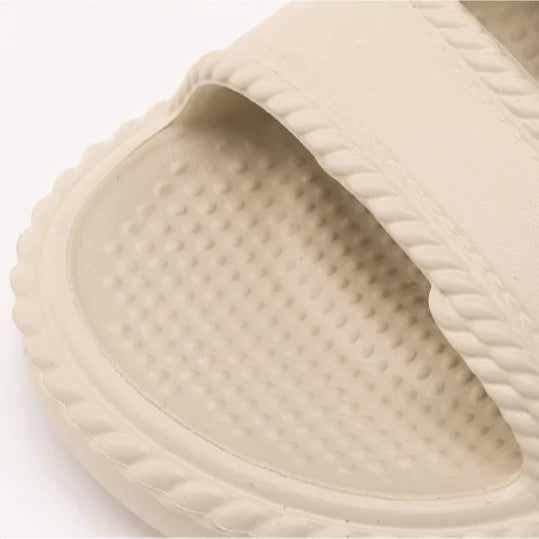 Beige slide sandal with textured sole on a white background, featuring text in Chinese.