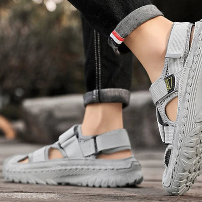 Gray sandals worn by a person on a wooden surface with a blurred background