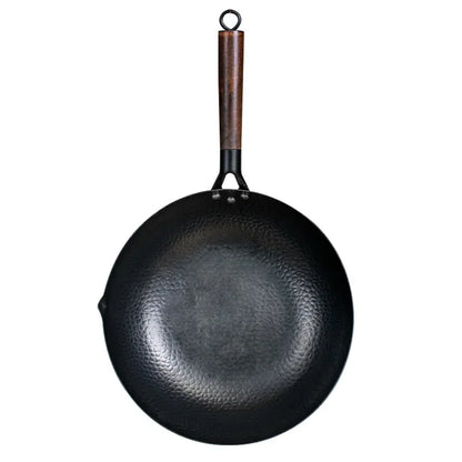 Black wok with a wooden handle on a white background