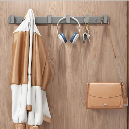 Coat, shoes, headphones, and a handbag hanging on a wooden door with a hook.