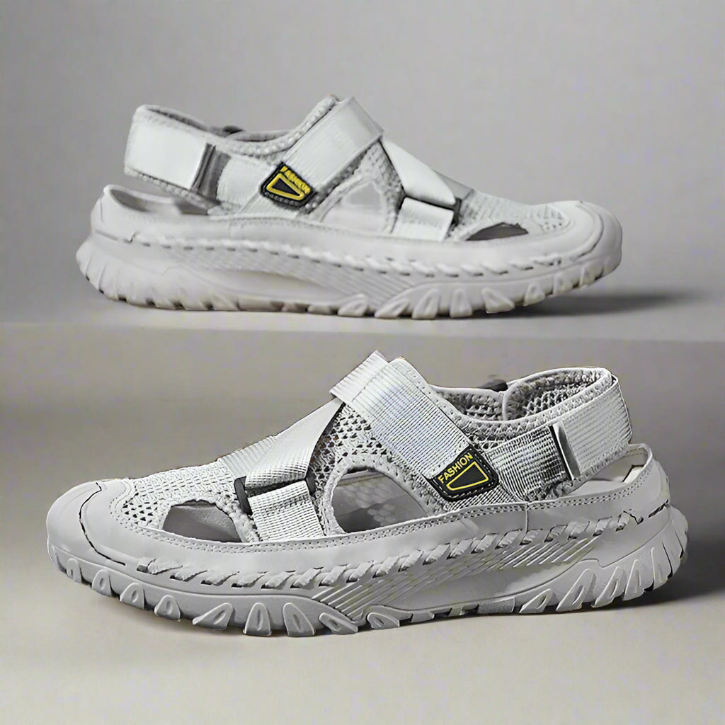 Pair of gray sandals with a visible brand logo on a reflective surface.