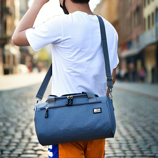 Person carrying a blue duffel bag in an outdoor setting