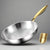 Stainless steel frying pan with gold handle on a dark background, featuring text about material and benefits.