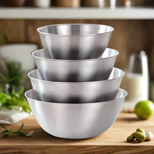 Set of four stainless steel bowls of different sizes on a white surface.