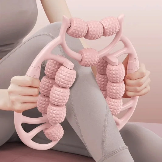 Person using a pink massage tool on their leg against a neutral background