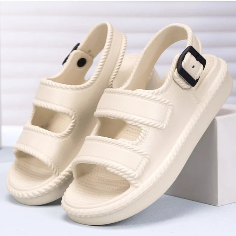 Beige sandals with black buckles on a white background