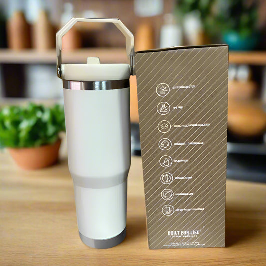 White tumbler with handle next to its packaging box on a cardboard background