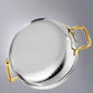 Stainless steel pot with gold handles on a light gray background