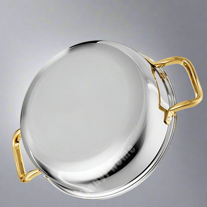 Stainless steel pot with gold handles on a light gray background