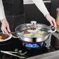 Stainless steel wok with glass lid on a stove, person holding it