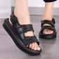 Black sandals worn on feet with a neutral background