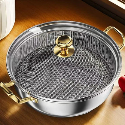 Metallic pan with a textured surface and gold handles on a wooden surface