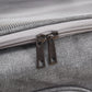 Close-up of a gray textured bag with a zipper and metal pull.
