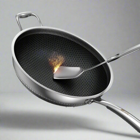 Stainless steel wok with a spatula on a light blue background