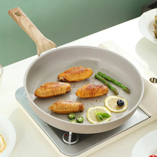 Frying pan with food on a stove against a green background