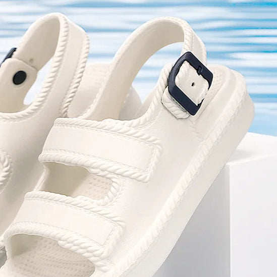 White sandals with a blue strap on a light blue background