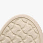 Close-up of a shoe sole with tread pattern and text on a white background
