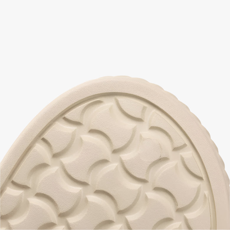Close-up of a shoe sole with tread pattern and text on a white background
