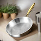 Stainless steel frying pan with gold handle on a dark background