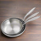 Set of stainless steel frying pans with food and vegetables on a white background