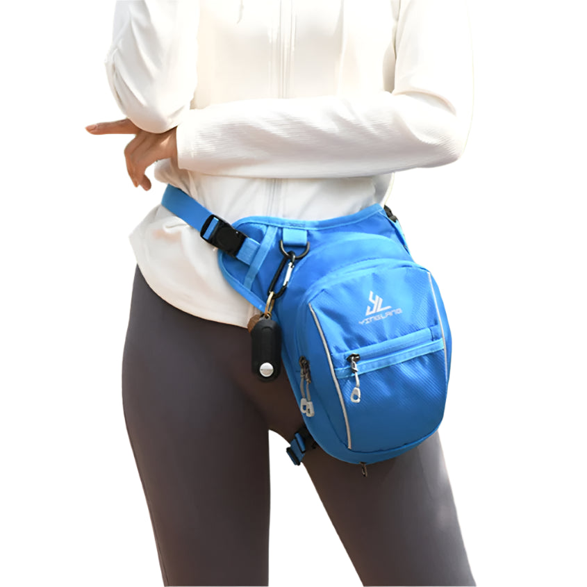 Person wearing a blue waist bag outdoors with greenery in the background