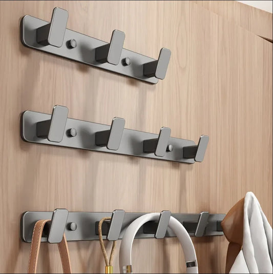 Set of metal hooks on a wooden wall with various items hanging from them.